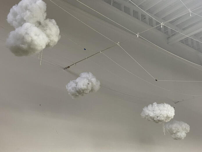 a dreamy pink and yellow sky is filled with purple, pink, and blue clouds. purple trees and birds are below.